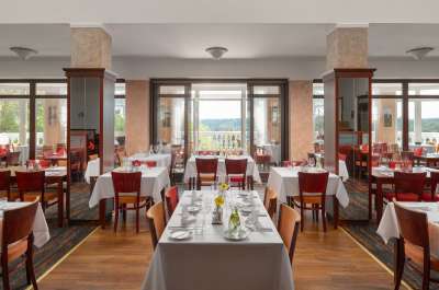 Restaurant mit weiß gedeckten Tischen und Blick auf die Terrasse im Spa Hotel Royal in Marienbad.